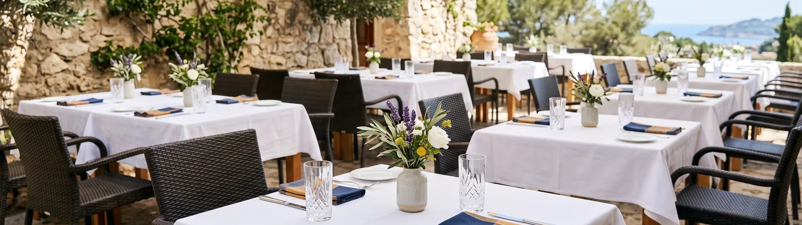 Mesas puestas en una terraza de restaurante soleada